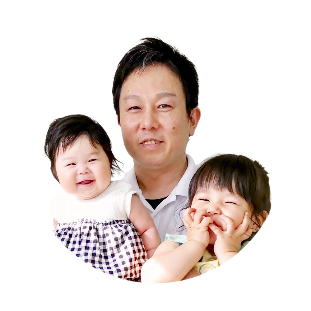 院長が笑顔の我が子2人を両腕に抱いている、丸く切り抜いた写真