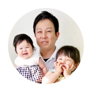 院長が笑顔の2人の子どもを抱いている、丸く切り抜いた写真