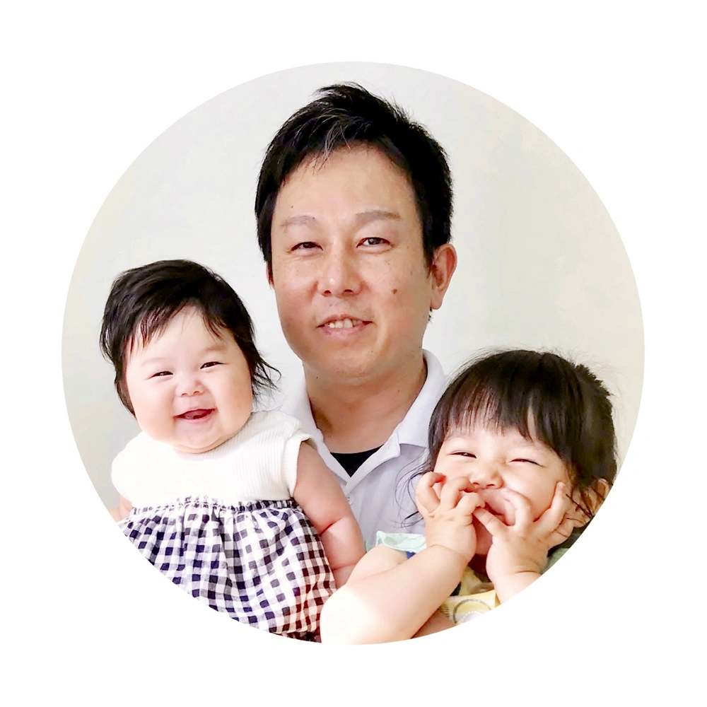 院長が笑顔の2人の子どもを抱いている、丸く切り抜いた写真