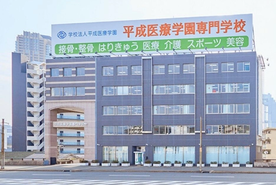 院長の出身校である平成医療学園専門学校の校舎。屋上の看板に接骨・整骨、はりきゅう、医療、介護、スポーツ、美容の学科名が並んでいます